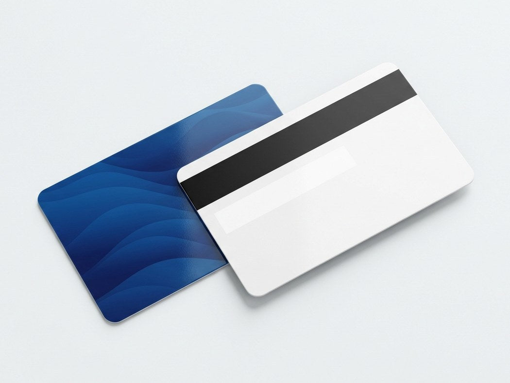 Tarjeta de PVC con banda magnética y panel de firma junto a otra impresa en azul
