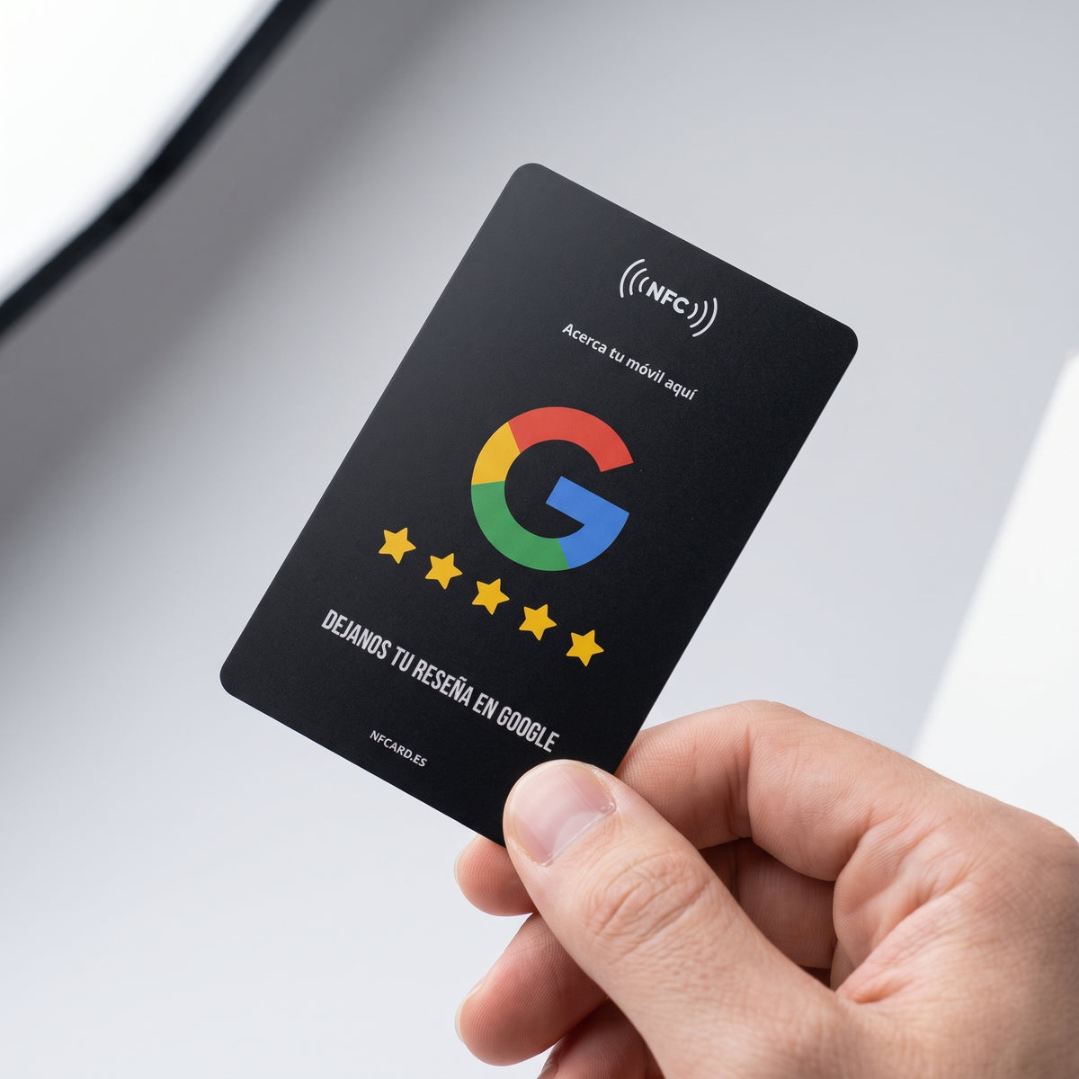 Mano sosteniendo la tarjeta NFC negra mate para reseñas de Google