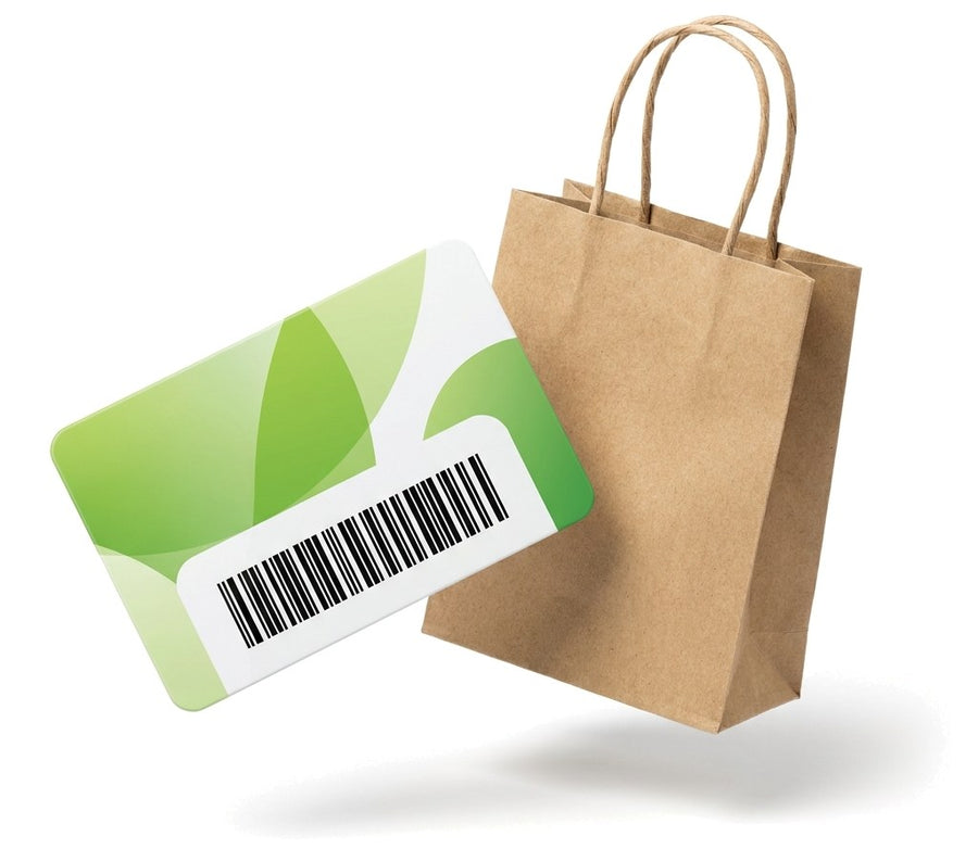 Tarjeta de compra de PVC verde con código de barras junto a una bolsa de papel