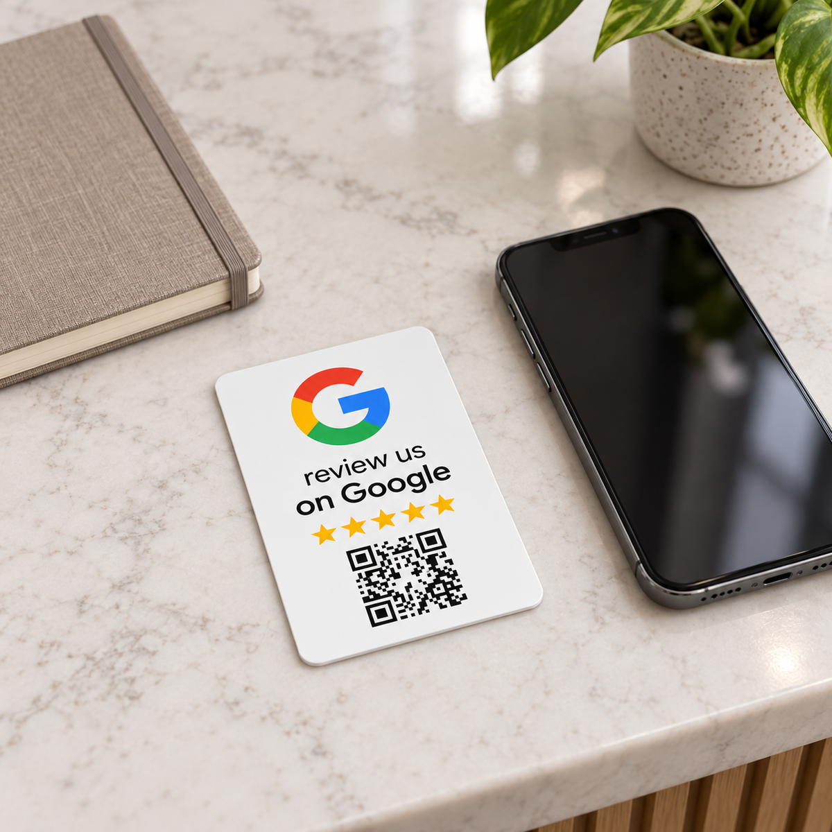 Tarjeta NFC Google Diseño G blanca completa sobre un mostrador junto a un móvil